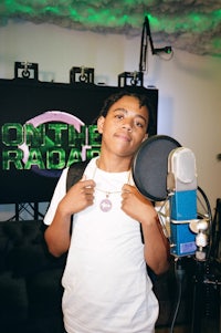 a young boy standing in front of a microphone