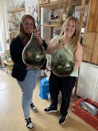 two women holding terrariums