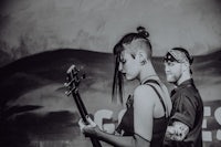 a black and white photo of a man and woman playing a guitar