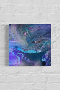 a blue and purple abstract painting on a brick wall