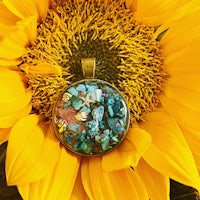 a sunflower with a colorful glass pendant on top of it
