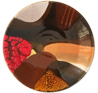 a plate with a brown, red, and orange design