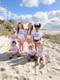 a group of children wearing t - shirts on the beach