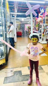 a young girl holding a balloon in a store
