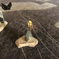 miniatures of a man on a rock with a bird on it