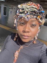 a woman wearing a beaded headband on a train