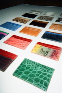 a group of different colored leather wallets on a table