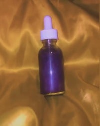 a bottle of purple liquid sitting on top of a yellow cloth