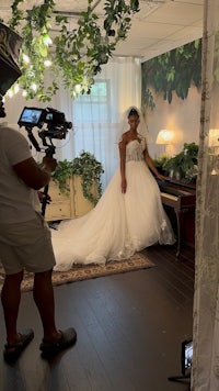 a woman in a wedding dress is being photographed in a room