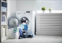 a laundry room with a washing machine and clothes