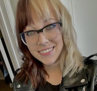 a woman wearing glasses and a leather jacket