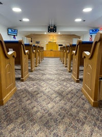 an empty church with wooden pews and a tv