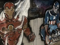 captain america and iron man are painted on a wall