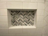 a tiled shower with a herringbone pattern