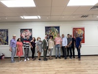 a group of people posing for a photo in an art gallery