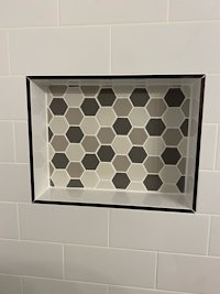 a bathroom with a hexagon tiled shelf