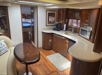 the interior of a motor yacht with a kitchen and dining area