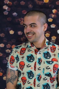 a man with tattoos wearing a shirt with skulls on it