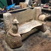 a carved bench with a fox on it
