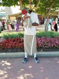 a man dressed up in a tuxedo and holding a flower