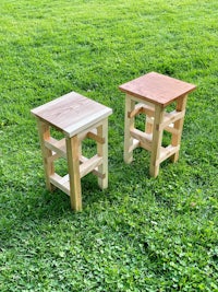 two wooden side tables on a grassy field