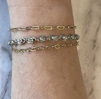 a woman's wrist with three gold bracelets on it