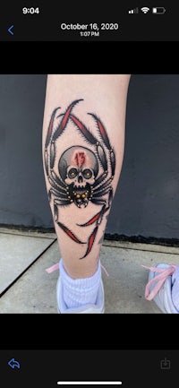a woman with a spider tattoo on her leg