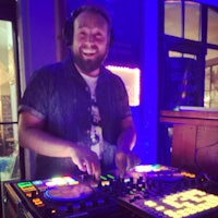 a dj is smiling in front of a dj deck