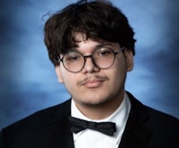 a young man wearing glasses and a tuxedo