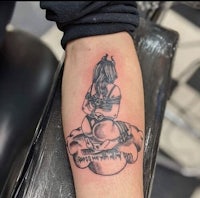 a tattoo of a girl sitting on a cloud