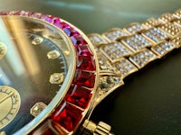 a close up of a gold and red watch