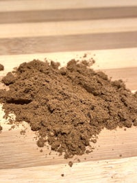a pile of brown powder on a wooden table