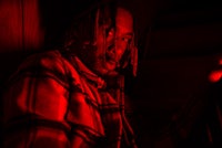 a man sitting in a dark room with a red light