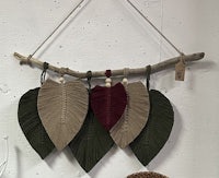 four leaves hanging from a branch on a wall
