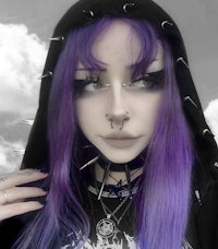 a girl with purple hair wearing a hoodie and spikes