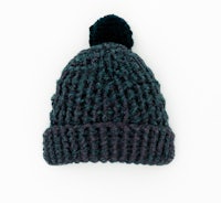 a knitted beanie with a pom pom on a white background