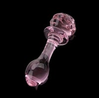 a pink glass pipe on a black background