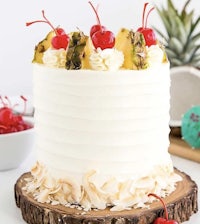 a white cake with pineapples and cherries on top