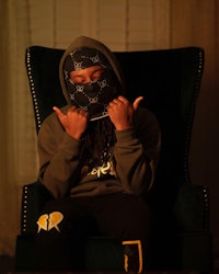 a man in a hoodie sitting in a chair