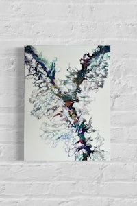 an abstract painting on a white brick wall