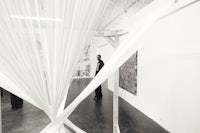black and white photo of a man standing in an art gallery