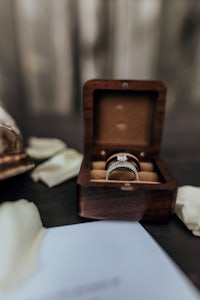 a wedding ring in a wooden box on a table