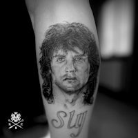 a black and white tattoo of a man with long hair