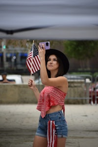 a woman taking a selfie with an american flag