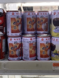many cans of chinese tea are on display in a store