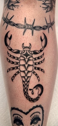 a tattoo of a scorpion with barbed wire