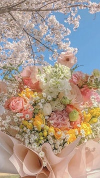 a bouquet of flowers under a cherry blossom tree