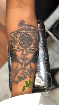 a tattoo of a woman with a clock on her arm