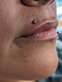 a woman with piercings on her lip