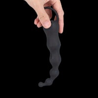 a person holding a black sex toy on a black background